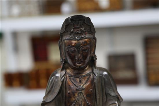 A Chinese bronze seated figure of Guanyin, with separate stand, 35.5cm.